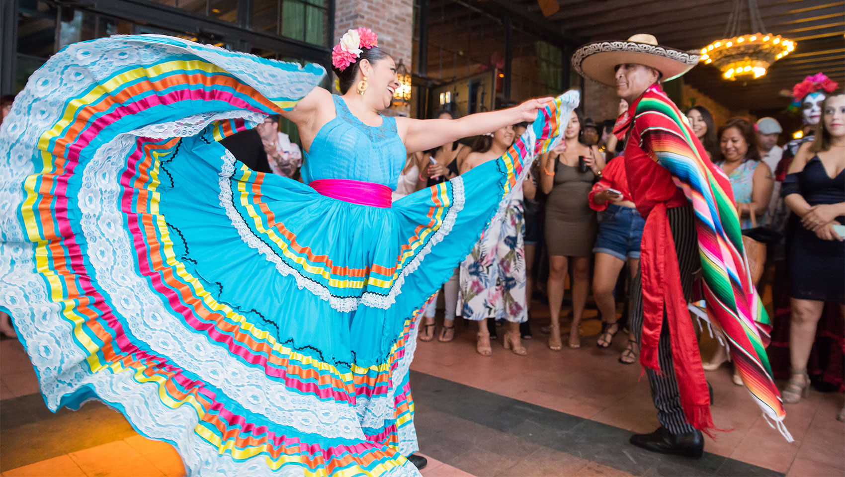 man and woman dressed in traditional outfits performing a dance