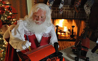 Santa actor in front of a fireplace